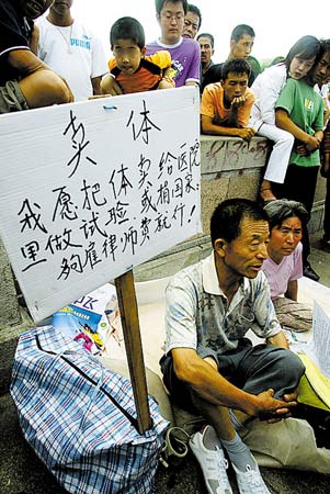 六旬夫妇当街举牌出售身体换取律师费(图)