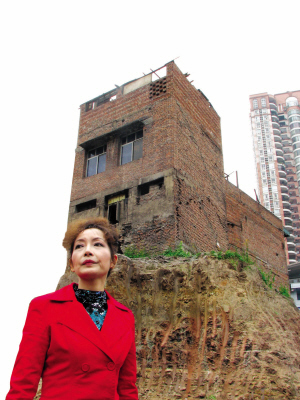 重庆最牛钉子户户主搬回孤楼 楼顶升起国旗(图)