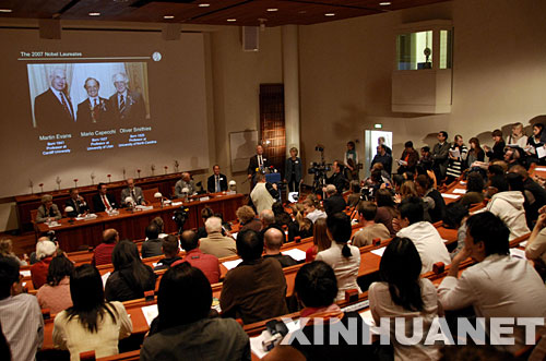 10月8日,瑞典卡罗林斯卡医学院宣布,将2007年诺贝尔生理学或医学奖授予(屏幕中从左至右)英国人马丁·埃文斯、美国人马里奥·卡佩基和奥利弗·史密斯,因为他们在改造活体内特定基因的“基因靶向”技术等方面做出了奠基性贡献。 新华社记者朱莲谊摄
