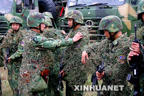 10月29日,参演官兵在进行个人隐蔽伪装。 当日,济南军区“铁拳-2007”复杂电磁环境下机步师实兵检验性演习参演部队万人千车历时两天,经过数百公里远程机动,完成了防强电磁干扰、防持久毒剂袭击、反敌机侦察等演练课目,顺利到达河南确山,进入作战部署阶段。新华社记者查春明摄