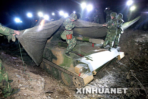 10月29日,参演官兵到达集结地域后,快速对装备进行隐蔽伪装。 当日,济南军区“铁拳-2007”复杂电磁环境下机步师实兵检验性演习参演部队万人千车历时两天,经过数百公里远程机动,完成了防强电磁干扰、防持久毒剂袭击、反敌机侦察等演练课目,顺利到达河南确山,进入作战部署阶段。新华社记者查春明摄