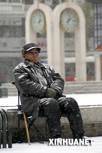 11月19日,一位老人在雪中休息。当日,冰城哈尔滨降下2007年冬的第一场雪。 新华社记者 王建威 摄