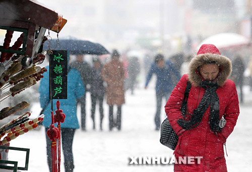 11月19日,市民在丹东街头冒雪前行。 辽宁大部地区从19日上午开始,迎来入冬以来最强的一次降雪过程。沈阳中心气象台当日下午对丹东、凤城发布了暴雪蓝色和黄色2个预警。