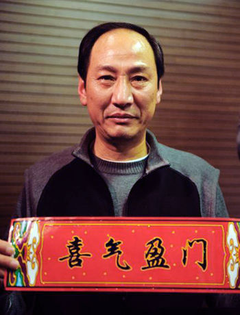 孙海平教练手拿“喜气盈门”的横幅预祝大家新春快乐