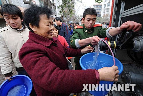 1月26日,贵州都匀市消防战士正在为市民供水。 当日,受冰灾影响,贵州电网公司都匀供电局的121条输电线路中断,造成都匀市停电停水,78个乡镇停电,都匀电网全面瘫痪,直接影响了40多万群众的生活。灾情发生后,贵州电网公司都匀电网派出3400多职工投入抗灾第一线,公安、消防等部门紧急调度消防车给群众送水,有关部门积极投入抗灾,预计明天可以争取局部供水供电。 新华社记者 杨楹 摄