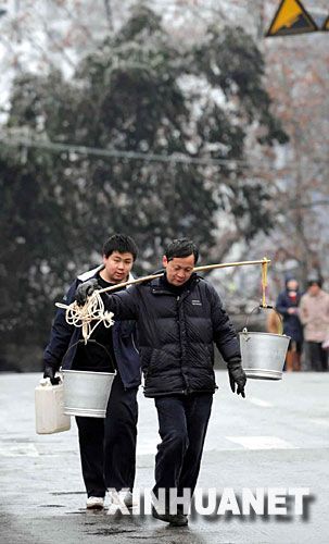 1月26日,贵州都匀市的两位市民在冰路上挑水。 当日,受冰灾影响,贵州电网公司都匀供电局的121条输电线路中断,造成都匀市停电停水,78个乡镇停电,都匀电网全面瘫痪,直接影响了40多万群众的生活。灾情发生后,贵州电网公司都匀电网派出3400多职工投入抗灾第一线,公安、消防等部门紧急调度消防车给群众送水,有关部门积极投入抗灾,预计明天可以争取局部供水供电。 新华社记者 杨楹 摄