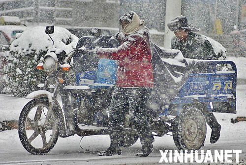 市民冒雪推车走在路上