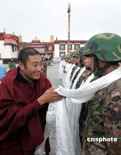 3月21日,拉萨大昭寺的僧人向在大昭寺广场上执勤的武警官兵敬献哈达,他们还为官兵们送上了生活慰问品。中新社发 廖攀 摄