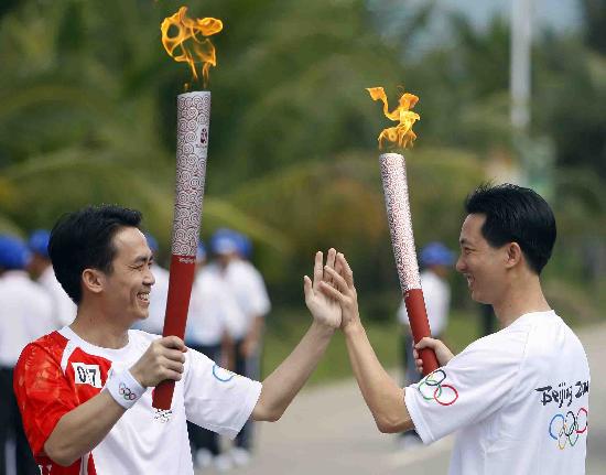 图文-奥运圣火在海南万宁传递 赖学鹏与王昌江击掌