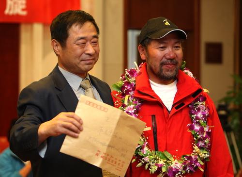 登山队员心系灾区,王勇峰将中国登山队员向灾区的捐款交到国家体育总局机关党委负责人手中。