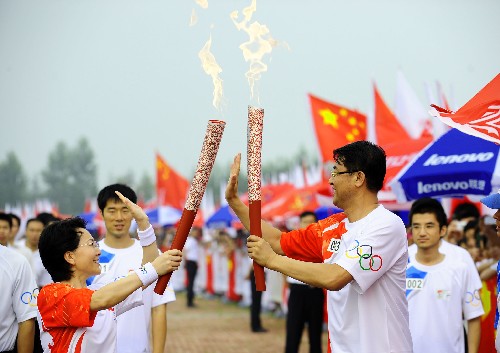 7月17日,第一棒火炬手,中国奥运第一人刘长春之子刘鸿图(右)与下一棒