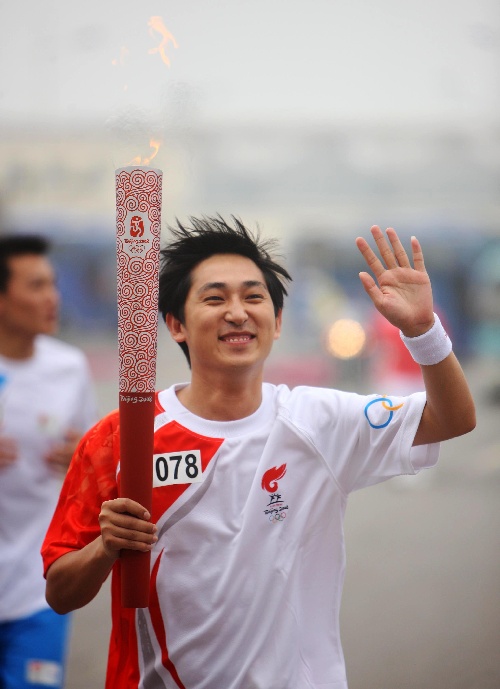 图文:奥运圣火在天津传递 火炬手张明在传递