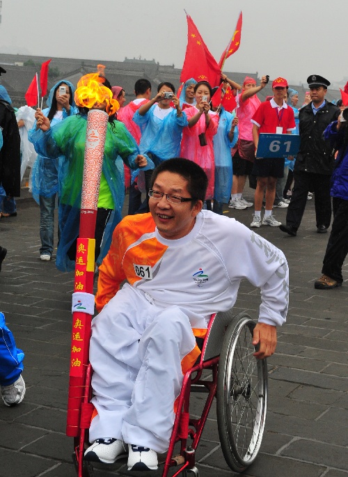 图文:残奥会圣火在西安进行传递 火炬手王延