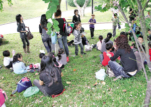昨天,在市区绣山公园秋游的学生和家长坐在草坪上休息.