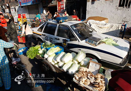 舟山路上卖菜的流动摊贩竟然把菜摊摆到了警车上.