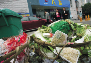 超市前堆放着烂菜叶,过期食品等垃圾,散发出酸臭味.