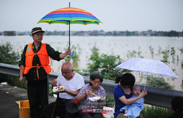 直击抚州洪灾 救援人员为吃饭灾民打伞