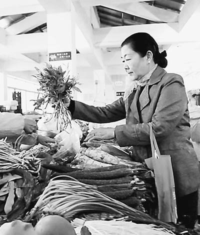 批发市场买菜的吴至明。 记者　朱磊摄 