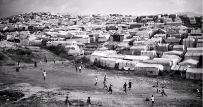 海地首都太子港,一群孩子在难民营旁的空地上踢球.资料图