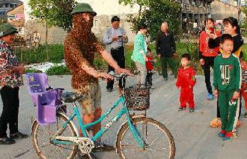 温州蜂农穿5万只蜜蜂“织”的蜂衣悠然骑车