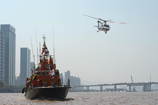 图为东海救助局救助直升机,搜救艇前往救援现场.