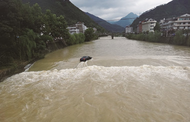道路塌方轿车坠溪 司机打开车窗蹚水上岸
