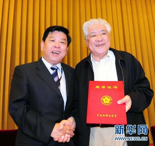 这是中国文联党组书记胡振民为李默然颁发荣誉证书.