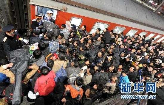 1月25日晚,北京西客站,上火车的乘客在车厢外等待上车.