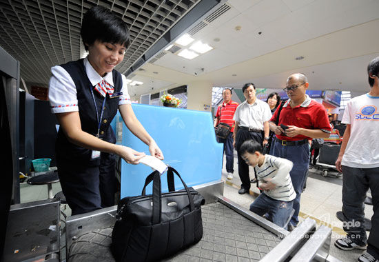 10月17日,海口美兰机场,南航工作人员为晚到旅客托运行李.