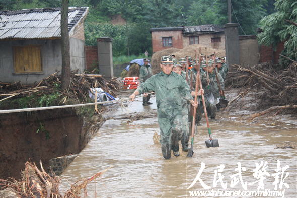 官兵们趟过湍急的洪水赶去救人    图片来源:人民武警报