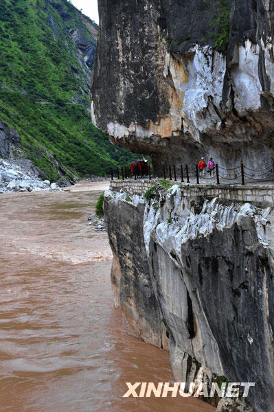 图为行走在险峻的虎跳峡景区栈道上的旅游者(8月20日摄).