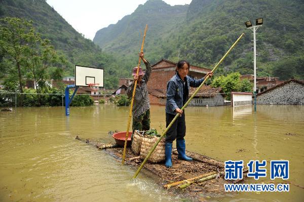 6月4日,在广西忻城县北更乡古利村,村民乘坐自制交通工具从篮球场上