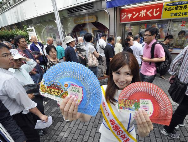7月7日,在日本首都东京的一个彩票站,人们排队购买彩票.