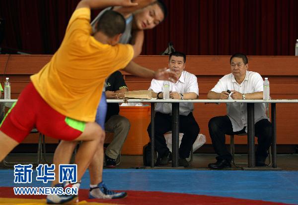 7月22日,国家女子摔跤队教练许奎元(右二)在观看小运动毖训练.