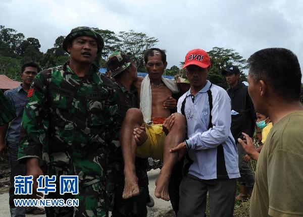 10月31日,救援人员在印度尼西亚明达威群岛的南巴盖岛转移一名受伤