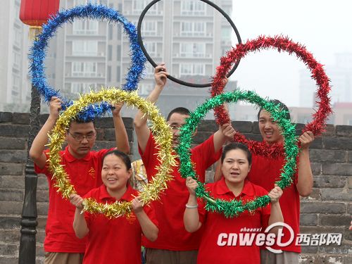 火炬传递沿途市民们摆出奥运五环造型为火炬手加油