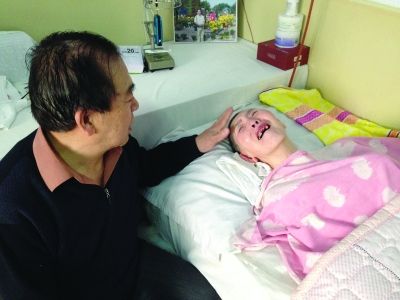 王家兴照顾瘫痪卧床的妻子。 王家兴照顾瘫痪卧床的妻子。