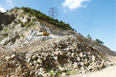 曹龍大道(快活嶺路段)工程的施工現場,兩臺鎬土機正在馬不停蹄地鑿除