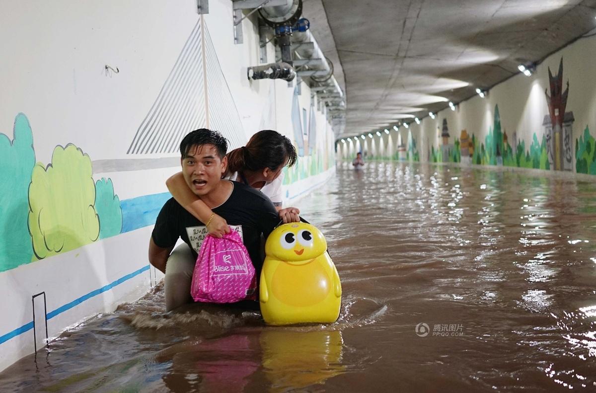 浙江金华桥洞积水男子驮妻女淌水赶高铁